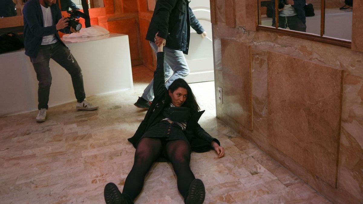 Una mujer mostró una foto de Le Pen con Putin en un acto de la candidata: fue sacada violentamente por los guardias